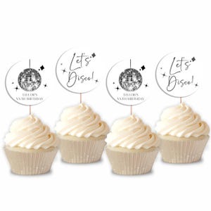 May include: Four white cupcakes with white frosting topped with round, white cupcake toppers that say "Let's Disco!" and feature a black and silver disco ball. The cupcake toppers also include the text "Taylor's XXth Birthday."