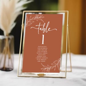 Número de mesa de casamento minimalista com folhas e galhos com modelo de nomes | Cartão de sinal de número de mesa marrom terracota para impressão editável B46