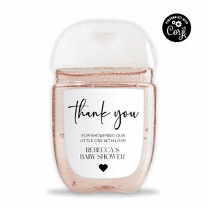 Könnte beinhalten: Eine durchsichtige Plastikflasche mit Händedesinfektionsmittel mit einem weißen Etikett, auf dem "Danke" und "FÜR DAS FEIERN UNSERES KLEINEN MIT LIEBE! REBECCAS BABY-PARTY" steht.