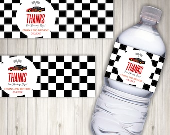 May include: Water bottle label with a checkered black and white background. The label has a red circle with a cartoon race car and the text "THANKS For Racing By! ETHAN'S 2ND BIRTHDAY 05.22.XX"