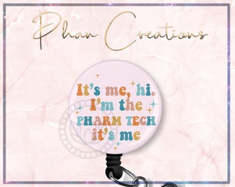 May include: A white retractable badge holder with a pink background and the text "It's me, hi. I'm the PHARM TECH it's me" in colorful retro font. The badge holder has a black retractable cord and a silver clip.
