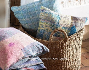 Könnte beinhalten: Ein geflochtener Seegras-Korb gefüllt mit bunten Patchwork-Kissen. Die Kissen sind aus recycelten Saris hergestellt und haben einen Vintage- und Boho-Stil.