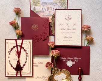 Könnte beinhalten: Ein Hochzeitseinladungs-Set aus dunkelrotem und cremefarbenem Karton mit goldenen Wachssiegeln, einer Karte mit Quaste und einem Umschlagfutter mit Herrenhaus-Motiv. Der Text nennt Stephanie Rosanna Pelaez und Mark Steven Fisher.