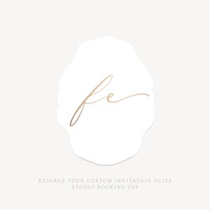Puede incluir: Una tarjeta de borde festoneado blanco con las letras cursivas doradas fe en el centro. Debajo de las letras, el texto dice: RESERVE YOUR CUSTOM INVITATION SUITE STUDIO BOOKING FEE. El diseño está centrado sobre un fondo liso de color claro.