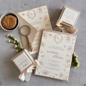 Schlicht, elegante Hochzeitseinladungen: Blumen im einladungsfarbigen Golddruck mit Prägung und floralen Namen der Brautpaare mit Goldfolie
