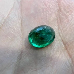 May include: A green oval-shaped gemstone with a faceted cut.