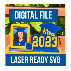 Könnte beinhalten: Ein blau-gelber Fotorahmen zum Thema Abschlussfeier mit dem Text "DIGITAL FILE" und "LASER READY SVG". Der Rahmen enthält ein Foto eines Absolventen mit Hut und Robe. Das Design beinhaltet eine Abschlusskappe und das Jahr "2023".