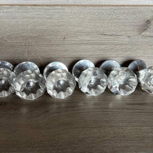 Könnte beinhalten: Acht klare Kristall-Türknöpfe aus Glas mit facettiertem Design. Die Knöpfe haben eine silberne Metallbasis.