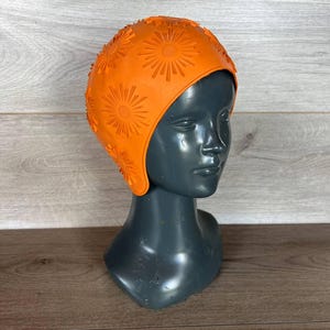 Czepek pływacki z pomarańczowej gumy w stylu vintage: wzór koła z lat 80.