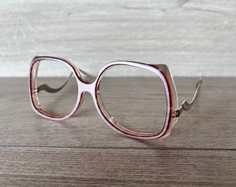 May include: A pair of pink and brown plastic framed spectacles with silver metal arms.