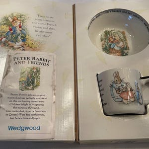 Peut inclure: Un coffret de vaisselle pour enfants Peter Rabbit and Friends de Wedgwood. L'ensemble comprend un bol en céramique blanche avec une illustration de Peter Rabbit, une tasse en céramique blanche avec une illustration de Peter Rabbit et une carte blanche avec une illustration de Peter Rabbit et un texte sur les aquarelles originales de Beatrix Potter.