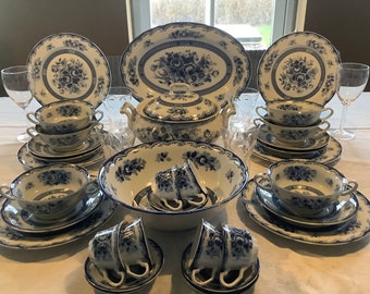 May include: A set of blue and white porcelain dinnerware with floral designs. The set includes a large serving bowl, soup bowls, plates, and teacups.