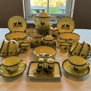 May include: A full yellow and green ceramic dinner service with a rooster design. The set includes plates, bowls, cups, saucers, a teapot, sugar bowl, creamer, salt and pepper pots, and egg cups.