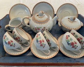 May include: A vintage tea set with floral patterns in shades of pink, blue, and green. The set includes a teapot, creamer, sugar bowl, four teacups, and four saucers.