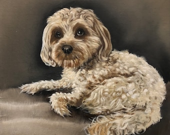 May include: A painting of a small, fluffy, light brown dog with dark eyes. The dog is lying on a brown surface and looking to the left. The painting is signed in the bottom right corner.