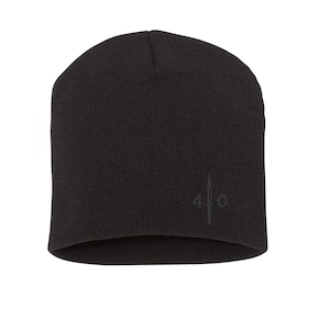 Peut inclure: Un bonnet en tricot noir avec un petit logo brodé qui dit "410" avec un design d'épée stylisé.