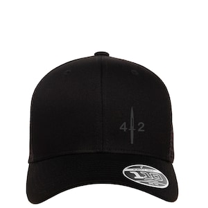 May include: Black baseball cap with a black mesh back. The front of the cap features a black embroidered design of a dagger with the number 42.