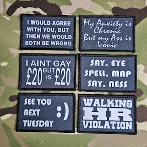 May include: Six dark blue rectangular patches with white text on a camouflage background. The patches feature various phrases, including "I AINT GAY BUT £20 IS £20" and "WALKING HR VIOLATION". Other patches say "See you next Tuesday".