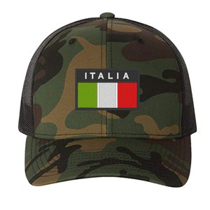 May include: A camouflage trucker hat with a black mesh back. The hat features a patch with the Italian flag and the word "ITALIA" in white letters.