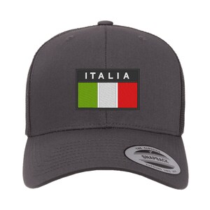 May include: A dark gray baseball cap with a black patch featuring the Italian flag and the word "ITALIA" in white text. The cap has a mesh back and a black adjustable strap.