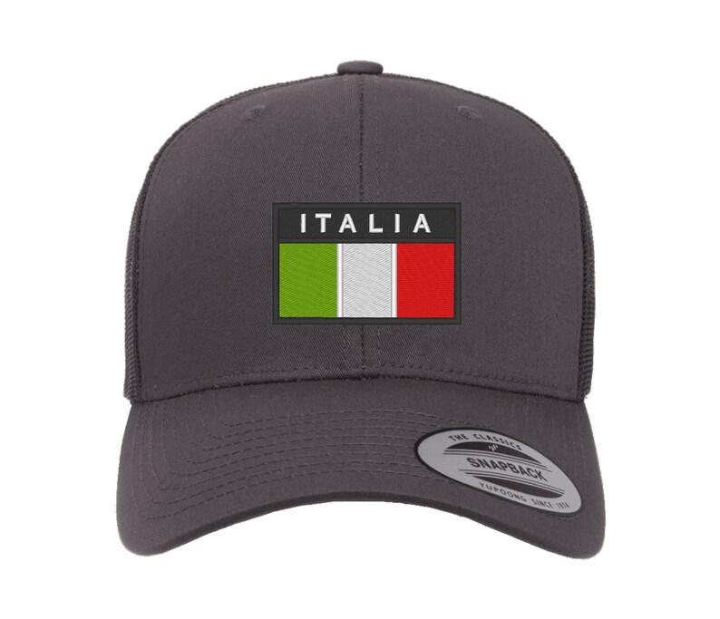 May include: A dark gray baseball cap with a black patch featuring the Italian flag and the word "ITALIA" in white text. The cap has a mesh back and a black adjustable strap.