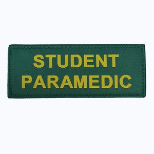 Può includere: Toppa rettangolare verde con il testo "STUDENT PARAMEDIC" in ricamo giallo.