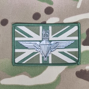 May include: A green embroidered patch with a white Union Jack flag and a silver parachute regiment badge in the centre.