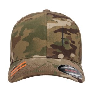 May include: A camouflage baseball cap with a black embroidered dagger on the front. The cap has a Flexfit logo on the back.