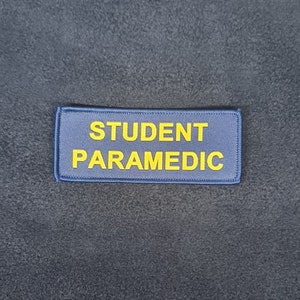 May include: A blue patch with yellow text that reads "STUDENT PARAMEDIC".