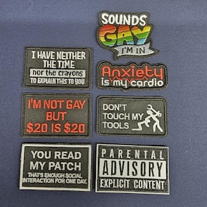 Op de afbeelding: Verzameling geborduurde patches met diverse slogans. Patches bevatten "Sounds Gay I'm In", "Anxiety is my cardio", en "Parental Advisory Explicit Content". Andere patches tonen "I have neither the time...", "I'm not gay but $20 is $20", "Don't touch my tools", en "You read my patch".