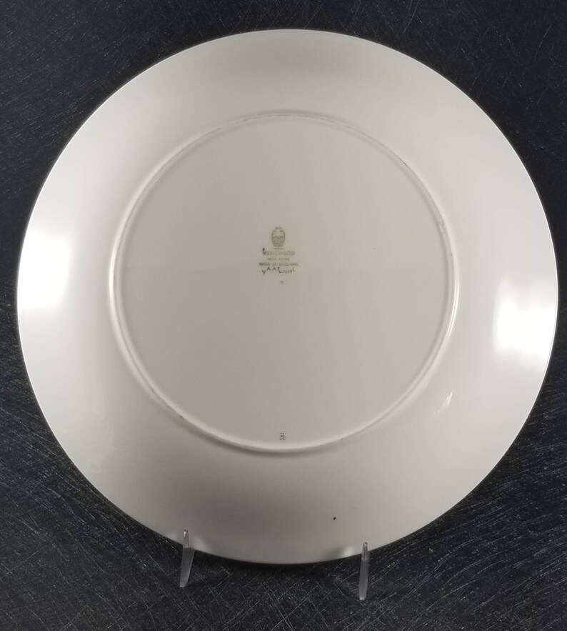 May include: White ceramic dinner plate with a green and gold Wedgwood logo and the text "Made in England" and "Yare" on the bottom.