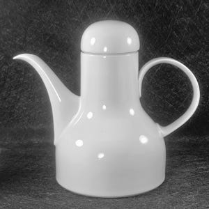 May include: A white ceramic coffee pot with a rounded body, a curved spout, and a loop handle. The pot has a lid and is designed with a minimalist aesthetic. The surface has a glossy finish, and the background is dark.