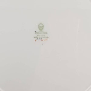 May include: White ceramic plate with a green Wedgwood logo and the text "Bone China Made in England" and a red stamp that says "YAA2".