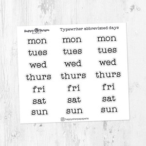 May include: Nine white stickers with black text, showing abbreviated days of the week in a typewriter font. The days of the week are: Monday, Tuesday, Wednesday, Thursday, Friday, Saturday, and Sunday.