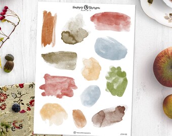 Pode incluir: Uma folha de adesivos de aquarela com 12 formas abstratas diferentes em tons de marrom, verde, azul e amarelo. Os adesivos são perfeitos para adicionar um toque de cor e textura a planejadores, diários e outras manualidades de papel. Happy Sherpa Paperie está impresso na folha.