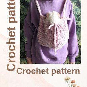 May include: A light pink crochet backpack with shoulder straps, holding a small white and tan pet. The text "Crochet pattern" is displayed vertically and horizontally. The text "By Irina Ustimeno" is also visible.