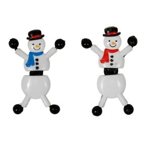 May include: Two white snowman figurines with black hats, arms, and feet. One snowman wears a blue scarf, the other a red scarf. Both have smiling faces and are in a playful pose, perfect for holiday decor.