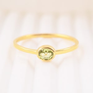 Peut inclure: Une bague en or avec une pierre ovale vert clair.