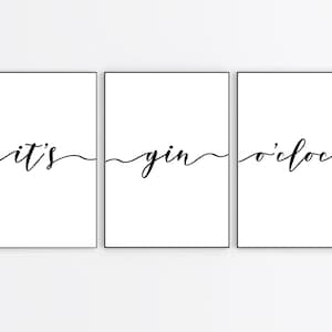 May include: Three black framed prints with white backgrounds. The prints are arranged horizontally and read "it's gin o'clock" in a cursive font.