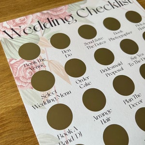 May include: A wedding checklist with a floral design. The checklist includes tasks such as booking the venue, ordering the cake, and planning the decor.