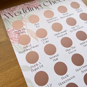 May include: A wedding checklist with a floral design. The checklist includes tasks such as booking the venue, sending save the dates, ordering the cake, and arranging hair.