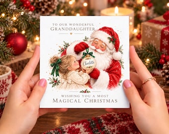 May include: A square Christmas greeting card featuring an illustration of Santa Claus and a young girl holding a gold ornament labelled Charlotte. The text reads To Our Wonderful Granddaughter and Wishing You A Most Magical Christmas.
