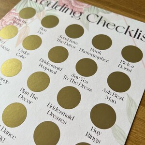 May include: A wedding checklist with gold circles and white text. The checklist includes tasks such as booking the venue, sending save the dates, ordering the cake, and buying rings.