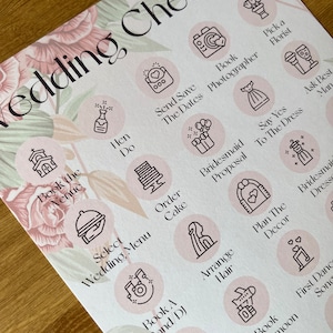 May include: A wedding checklist with pink floral accents and icons representing different tasks to plan for a wedding. The checklist includes tasks such as booking the venue, sending save the dates, ordering the cake, and planning the decor.