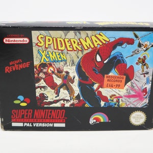 May include: A Super Nintendo game cartridge box for Spider-Man and the X-Men: Arcade's Revenge. The box features a colorful illustration of Spider-Man swinging through the air with the X-Men in the background. The box is black with a red and white Nintendo logo and the text "Super Nintendo Entertainment System" and "PAL Version".