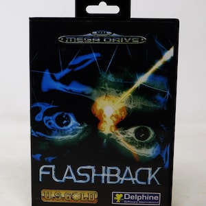 May include: A black Sega Mega Drive game cartridge with a colourful image of a person's eyes and a laser beam on the front. The game title is "Flashback" and the publisher is "US Gold".