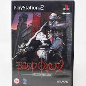 May include: PlayStation 2 video game case with a black background and a red and black image of two characters fighting. The game is called "Blood Omen 2: The Legacy of Kain Series" and has a 15 rating.