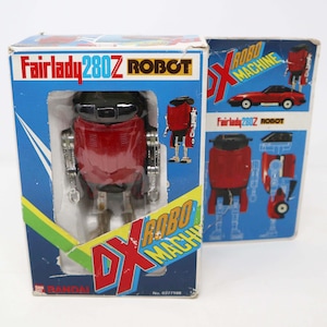 May include: A red and silver Fairlady 280Z Robot toy in its original box. The box has a blue background with the words "Fairlady 280Z Robot" and "DX Robo Machine" printed on it. The toy is a transforming robot that can change into a car.