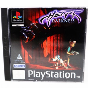 Peut inclure: Boîte de jeu PlayStation pour Heart of Darkness. La jaquette présente un monstre violet et noir aux yeux rouges brillants, un garçon avec une arme à feu et un chien. Le jeu est classé PAL.