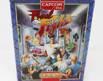 Può includere: Una scatola blu e viola per il videogioco Final Fight, che mostra una scena di un uomo che combatte in una carrozza della metropolitana. La scatola ha il testo "CAPCOM USA" e "U.S. GOLD" su di essa.